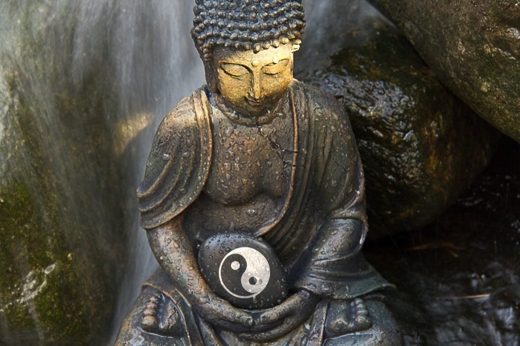 Statue chinoise spirituelle tenant un symbole de Yin Yang dans des couleurs noires et blanches