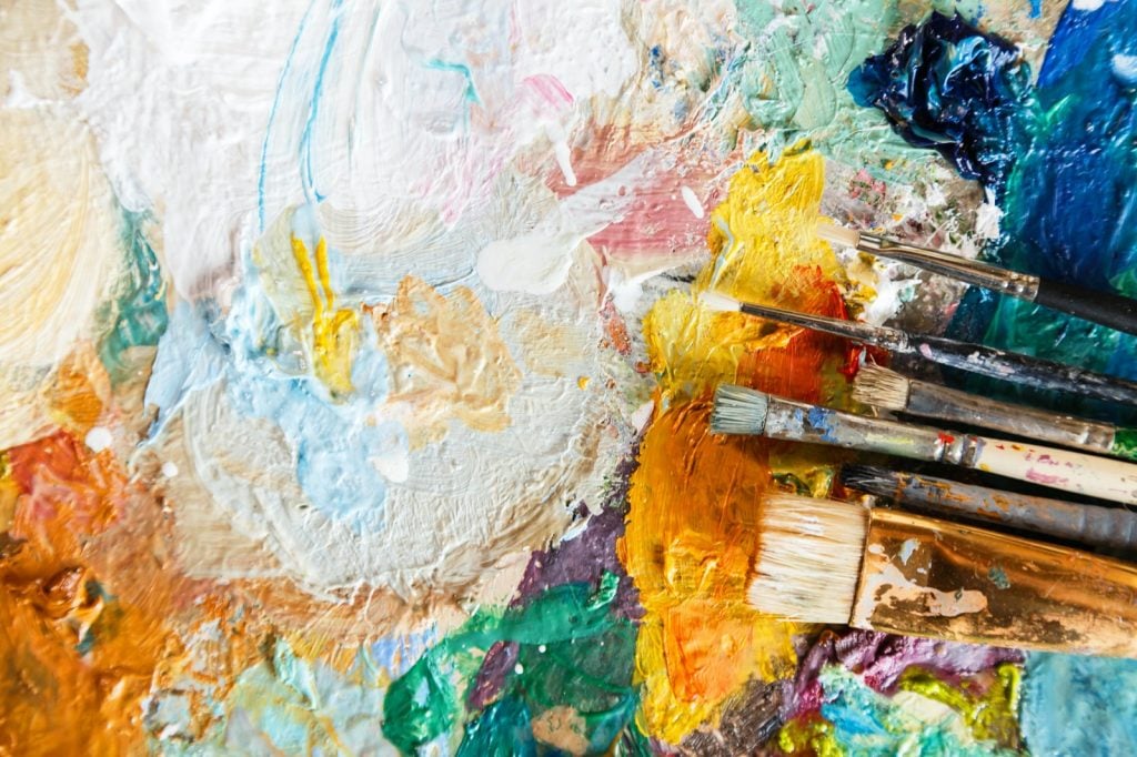 Artist palette with mixed colors making shades of white