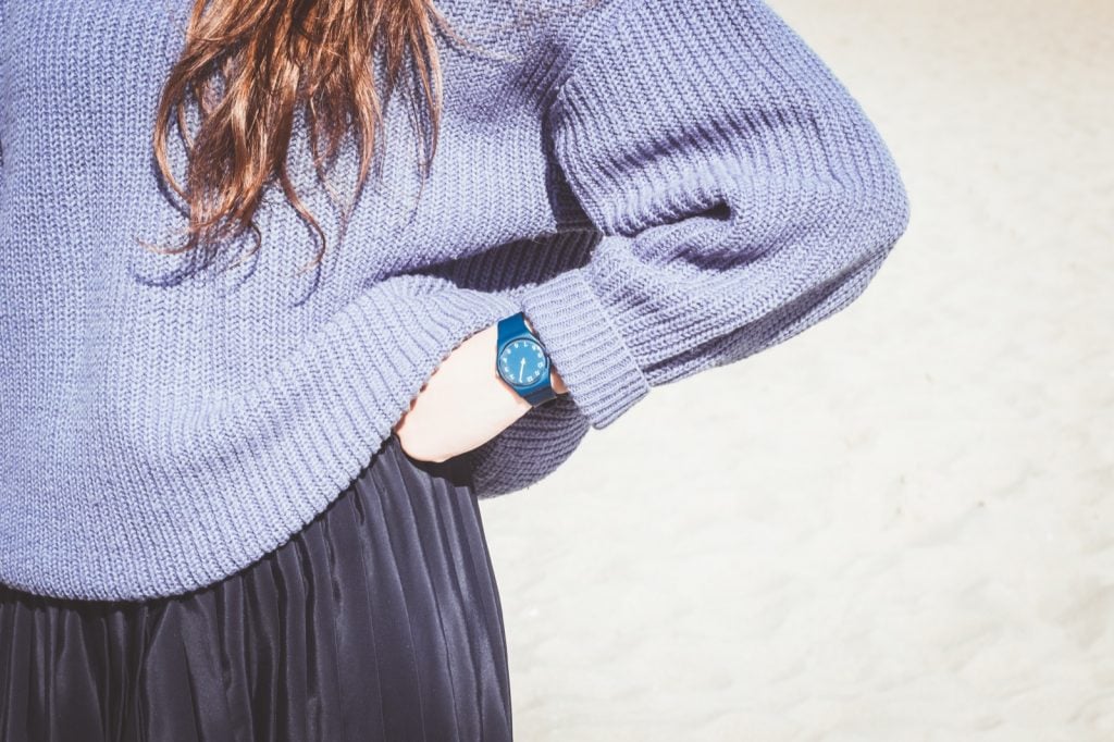 Femme en pull portant une montre bleue