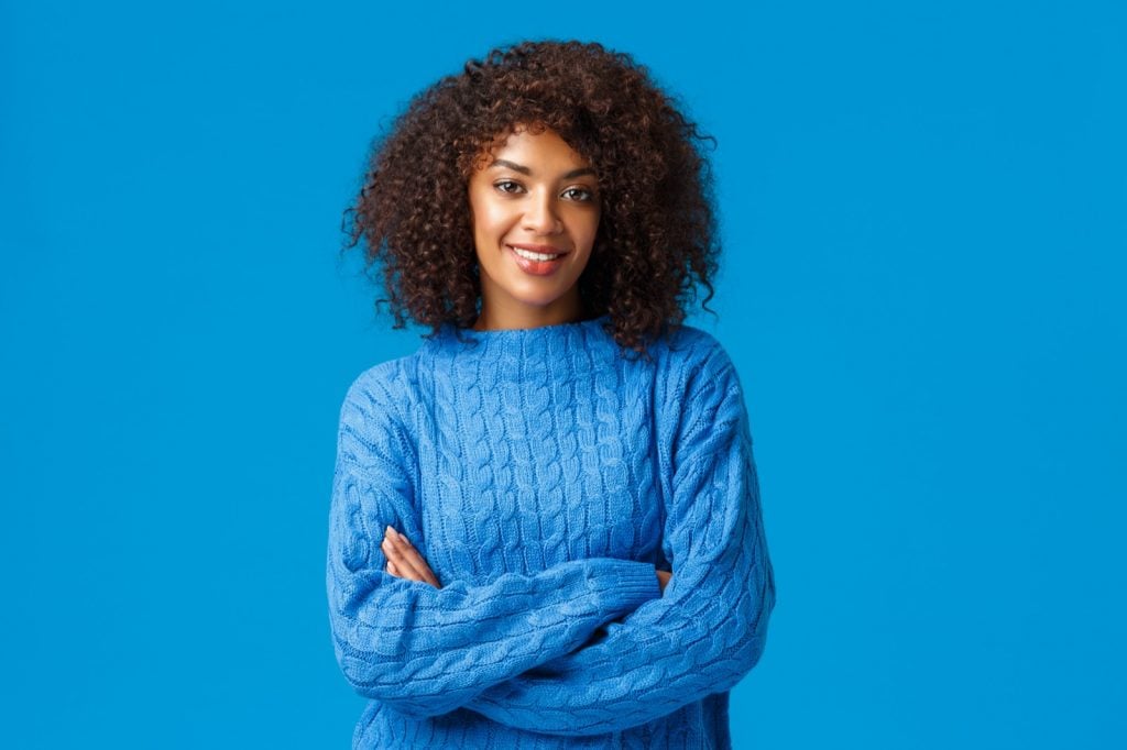 Confident African American woman with afro haircut in blue clothes